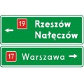 Znak E-2B - Drogowskaz tablicowy umieszczany nad jezdnią - Generacja I